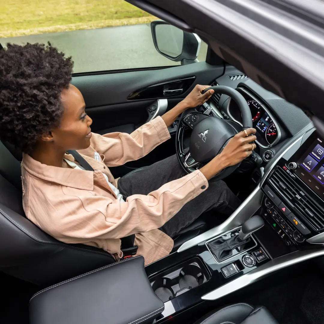a woman driving a 2025 mitsubishi eclipse cross showcasing the interior