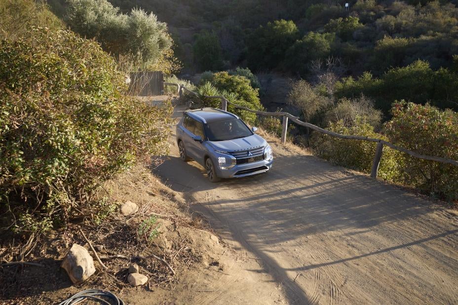 Blue outlander driving on a dirt road
