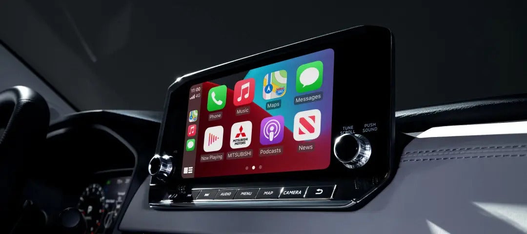 Close-up of the 2025 Mitsubishi Outlander PHEV infotainment display with Apple CarPlay icons.