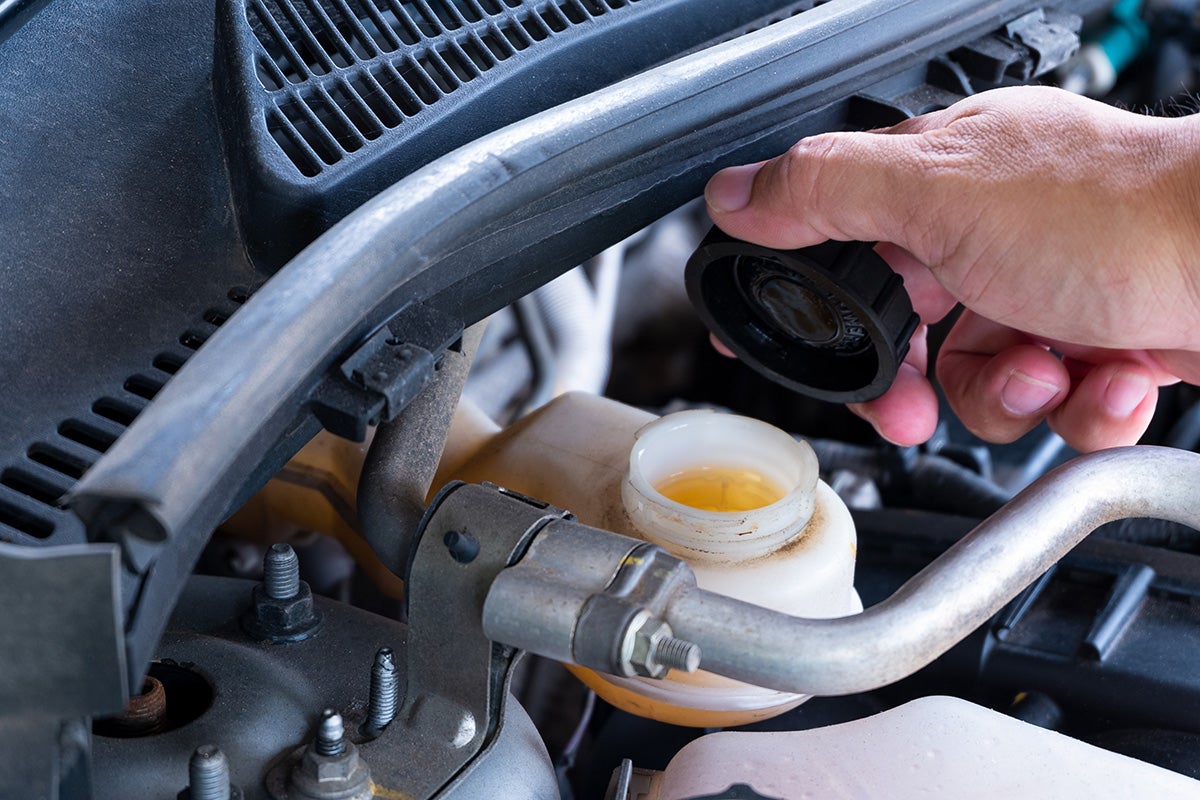 a person checking the fluid levels under the hood of a vehicle