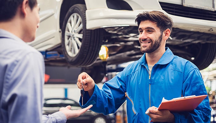 Arrow Mitsubishi alignment technician inspecting a vehicle