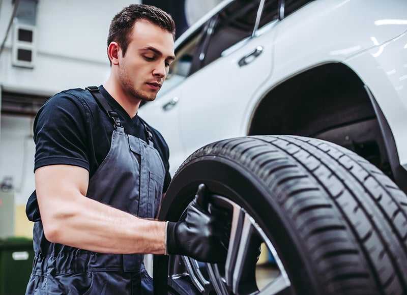 a service technician checking a tire